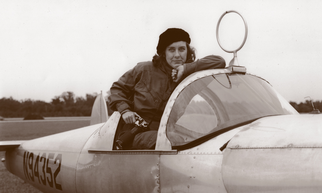 Woman in old fashioned aircraft.