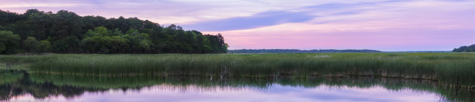 A salt marsh reflecting the sky at sunset.