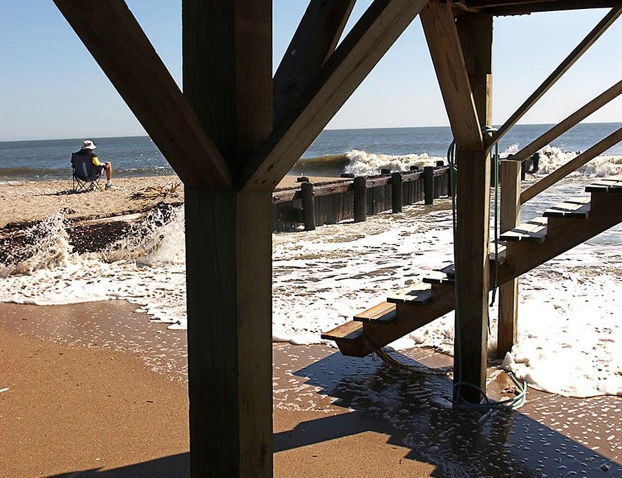 Beach showing signs of erosion under pier.