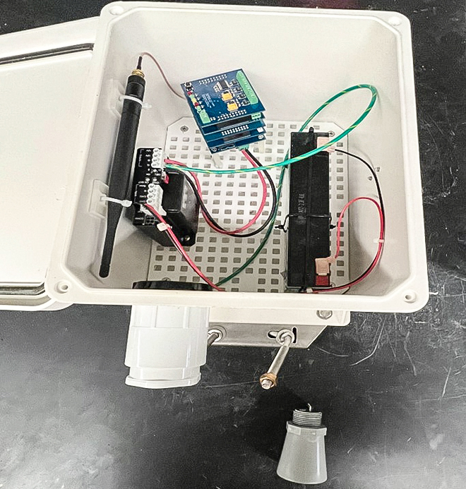 The inside of a water level sensor, a plastic box showing various wires and electronics.